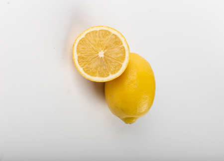 Whole and half lemon isolated on white. top view