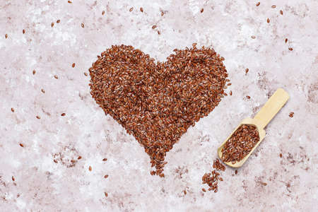 Heart shaped flax seeds on concrete background with space for copy,top viewの写真素材