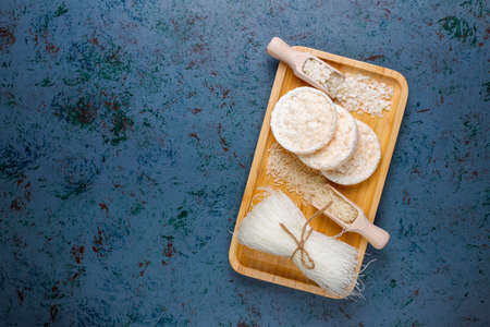 Rice flakes,rice noodles,rice bread and rice on dark background,top view