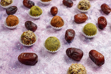 Homemade healthy vegan raw energy truffle balls with dates and walnuts,matcha powder,cocoa powder on...