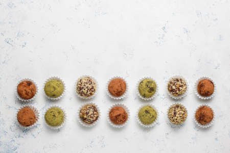 Homemade healthy vegan raw energy truffle balls with dates and walnuts,matcha powder,cocoa powder on light backgroundの写真素材