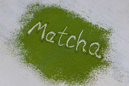 Word matcha made of powdered matcha green tea and bamboo spoon on white background. Copy spaceの写真素材