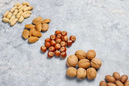 Assortment of nuts on concrete background.Hazelnuts, walnuts, pecans, peanut,almonds,top view