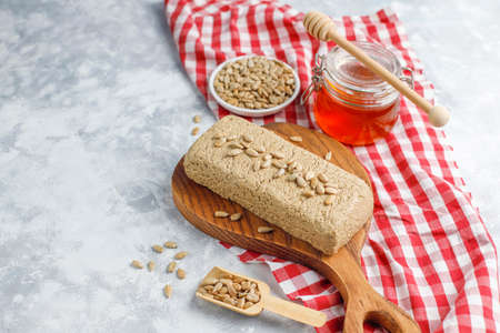Homemade sunflower halva on cutting board with sunflower seeds