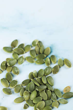 Green fresh pumpkin seeds on a marbleの写真素材