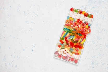 Colorful candies, jelly,marshmallow on light background. Top view with copy space