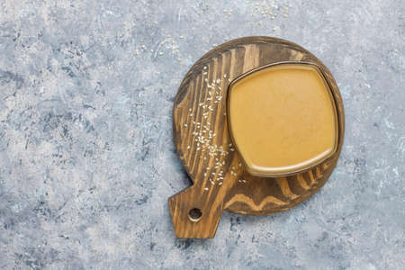 Bowl of tahini with sesame seeds on concrete backgroundの写真素材