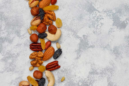 Assortment of nuts in ceramic plates. Cashew, hazelnuts, walnuts, pistachio, pecans, pine nuts, peanut, raisins.top viewの写真素材