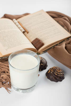 Chocolate buns with a glass of milk and a book asideの写真素材