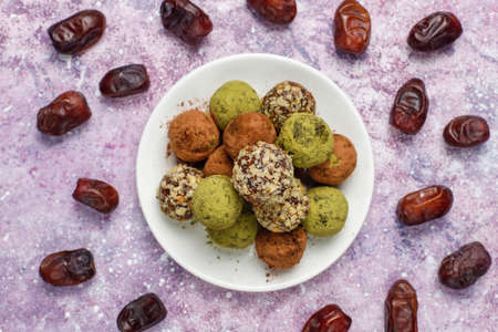 Homemade healthy vegan raw energy truffle balls with dates and walnuts,matcha powder,cocoa powder on...