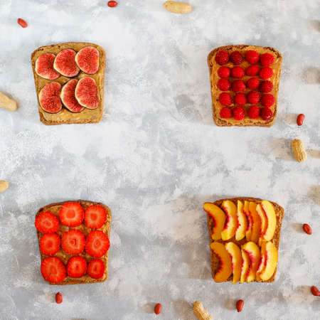 Traditional American and European summer breakfast: sandwiches of toast with peanut butter, berry,peach,fig, strawberry,raspberry, copy space top viewの写真素材