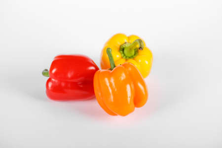 Tricolor peppers on white background. Top view