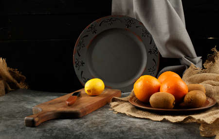 Orange, lemona nd kiwies in a platter.