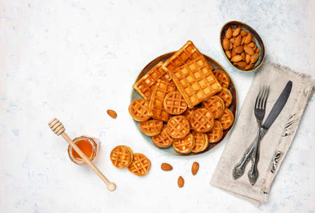 Traditional belgian waffles with fresh berries and honey on grey concrete background. Flat lay, top view, copy space.の写真素材