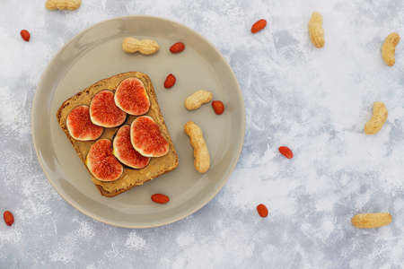 Traditional American and European summer breakfast: sandwiches of toast with peanut butter, berry,peach,fig, strawberry,raspberry, copy space top viewの写真素材