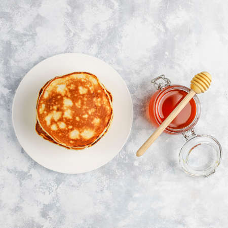 Homemade breakfast: american style pancakes served with pears and honey with a cup of tea on...