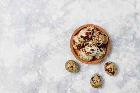 Quail eggs on a white-grey concrete background