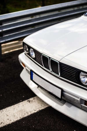Old model white sedan lights and bumper