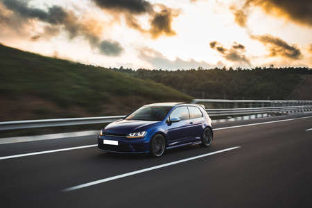 Black car on the road in a cloudy weatherの写真素材