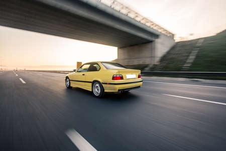Yellow taxi car on the highway under the bridge