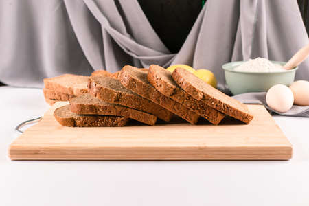 Thinly sliced dark wheat bread on a wooden board