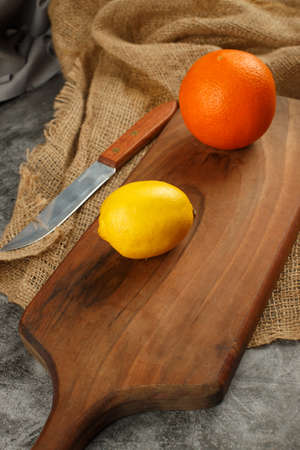 A lemon with and orange on the wooden board.の写真素材