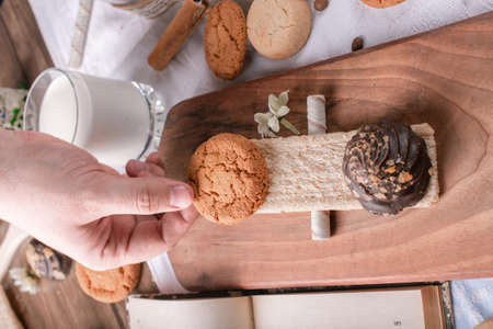 Putting a cookie on a wooden board on a piece of cracker