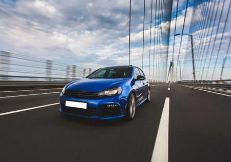 Blue hatchback car in parking mode in the bridgeの写真素材