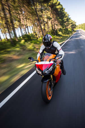 Orange color motorcycle with a driver in helmet