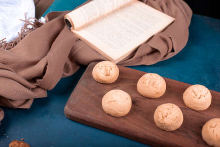 Butter cookies and a cookbook on a cutting board