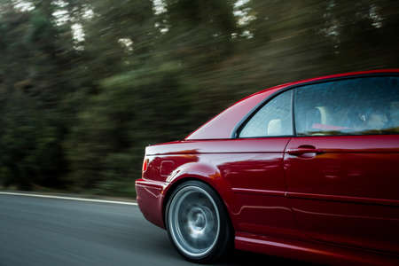 Back right door and wheel of a red sedanの写真素材