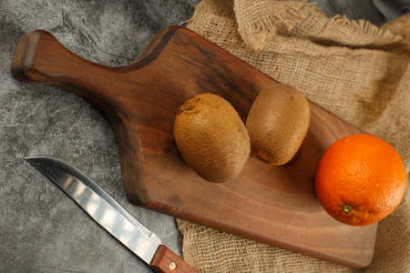 Kiwies and an orange with a knife. Top view.の写真素材