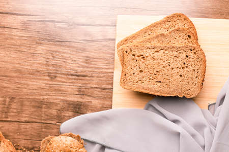 Three dark bread slices on a wooden table
