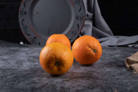 Oranges in a rustic space with a shadow on them.の写真素材