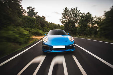 Blue sport car high speed drive in the forestの写真素材