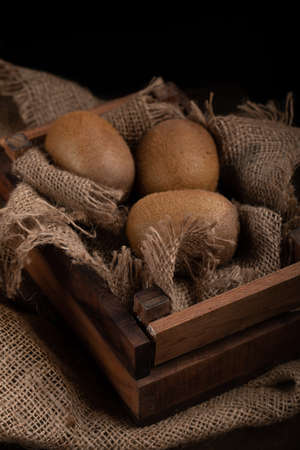 Kiwies in a rustic tray. Dark photoshooting.の写真素材