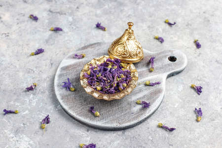 Assortment of dry tea in golden vintage mini plates.Tea types background:hibiscus,chamomile,mixed...