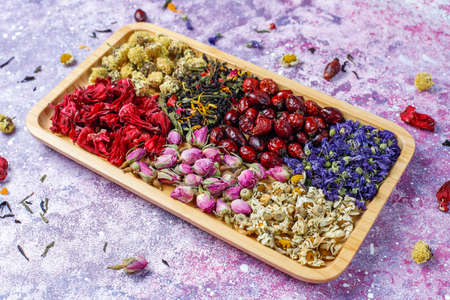 Assortment of dry tea in golden vintage mini plates.Tea types background:hibiscus,chamomile,mixed...