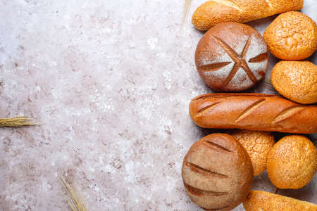 Different kinds of fresh bread as background, top viewの写真素材