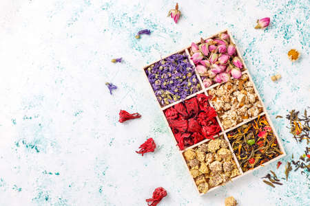 Assortment of dry tea in golden vintage mini plates.Tea types background:hibiscus,chamomile,mixed black tea,dry roses,butterfly pea teaの写真素材