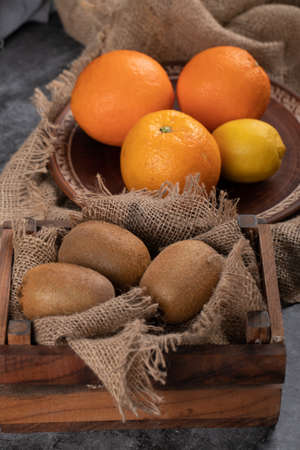 Kiwi and oranges in rustic trays.の写真素材