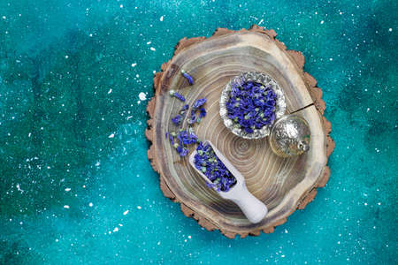 Assortment of dry tea in golden vintage mini plates.Tea types background:hibiscus,chamomile,mixed black tea,dry roses,butterfly pea teaの写真素材