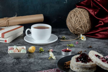 A cup of tea with turkish sweet lokum with rice crackersの写真素材