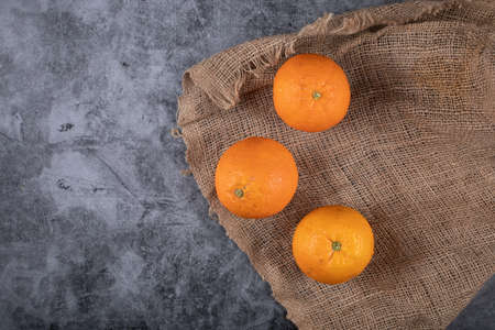Citrus oranges on a piece of burlap. Top view.