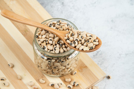 Glass jar of white kidney beans on wooden boardの写真素材