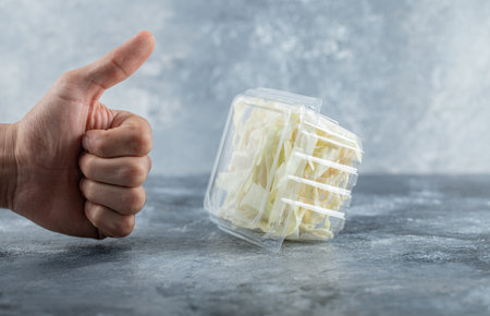 Man hand gesturing thumb up to fresh cheeseの写真素材