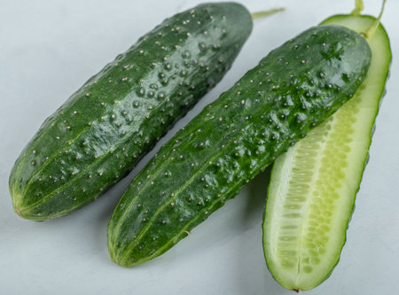 Close-up of fresh cucumbers and slices isolated on white background.の写真素材