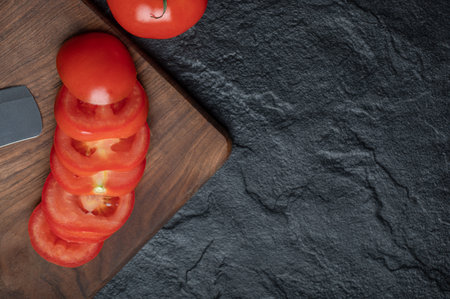 High angle view of freshly picked, juicy tomatoes on dark stone backgroundの写真素材