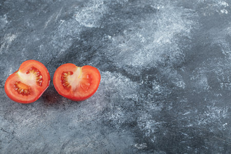 Half cut fresh organic tomato on grey backgroundの写真素材