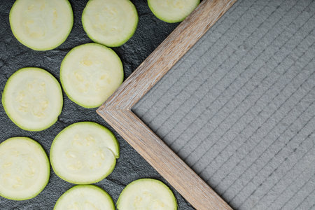 Fresh zucchini and slices of zucchinis on wooden tableの写真素材